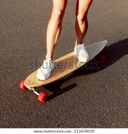 Young woman down the street with a skateboard