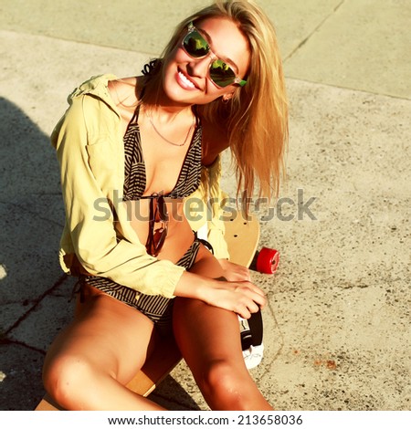 Outdoor summer closeup portrait vintage hipster Instagram colors of pretty blonde smiling sport woman with longboard in bikini in hot summer weather