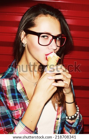 Young sexy brunette girl fashion closeup portrait eating ice-cream with her red nice lips on red background outdoor after night party lifestyle trendy closeup