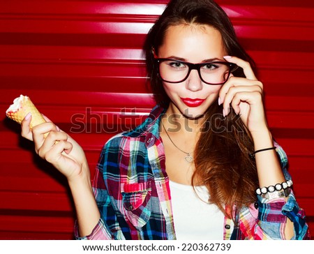 Outdoor fashion stunning closeup  portrait of pretty attractive nice girl with red lips ice-cream and glasses posing on red vivid color urban background