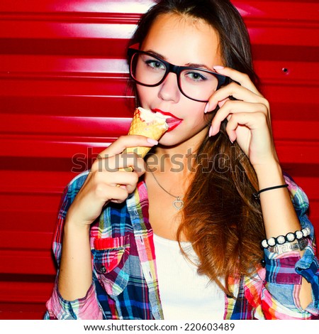 Young sensual sexy brunette fashion woman closeup portrait eating vanilla ice-cream corn on red background in the night
