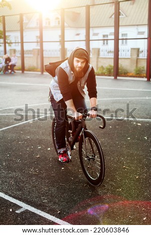 young hipster bearded handsome man riding sport style fixed gear bicycle in autumn urban style street neighborhood