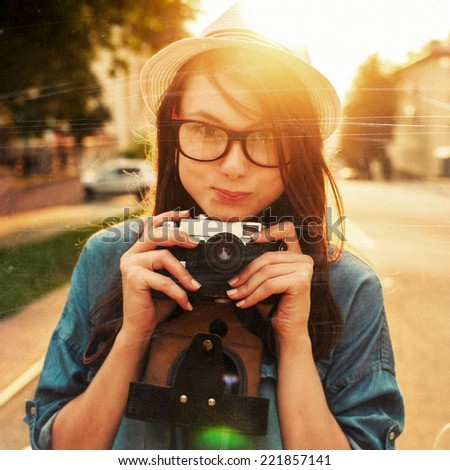 Pretty young hipster woman outdoor summer closeup portrait with vintage camera in her hands