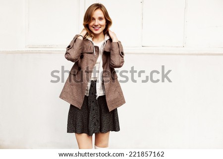 Outdoor autumn fall portrait of pretty young fashion smiling happy sensual woman dressed in warm woolen coat and skirt on white background
