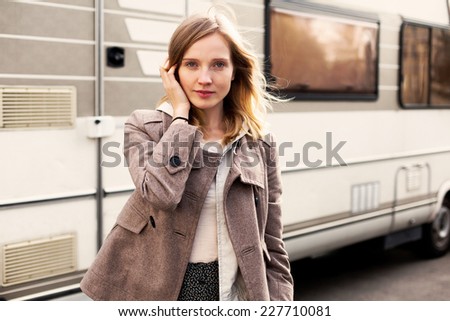 Young pretty sensual blonde fashion autumn woman posing outdoor on the street in windy fall weather with deep eyes look