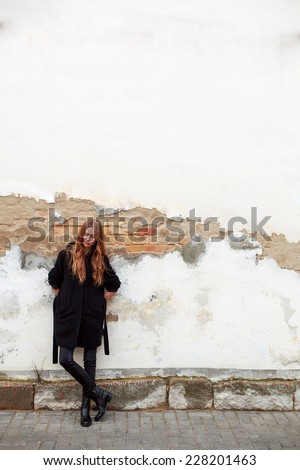 Pretty young fashion sensual blonde said dreaming woman posing outdoor on old wall background