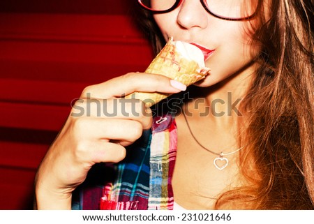 Closeup fashion portrait of young sexy hipster sensual red lips girl eating ice-cream sexy way on red background