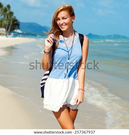 Pretty young beautiful sensual blonde woman posing on the beach and have fun alone near blue sea and sky smiling happy face