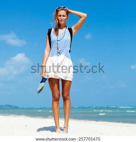 Thinking and surprised mood woman posing on the beach in summer vacation tourist style