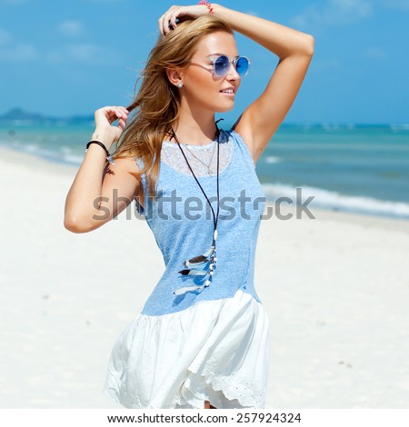 Outdoor fashion lifestyle summer vacation tropic portrait of pretty young beautiful sensual stunning woman blond hairs posing on the paradise beach