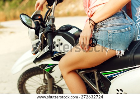 Outdoor summer portrait of young pretty blonde woman riding cross motorcycle traveling and having fun