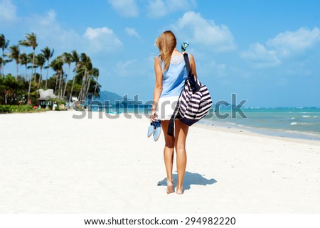 Lonely lifestyle portrait on blonde woman waiting somebody on the beach stylish back picture