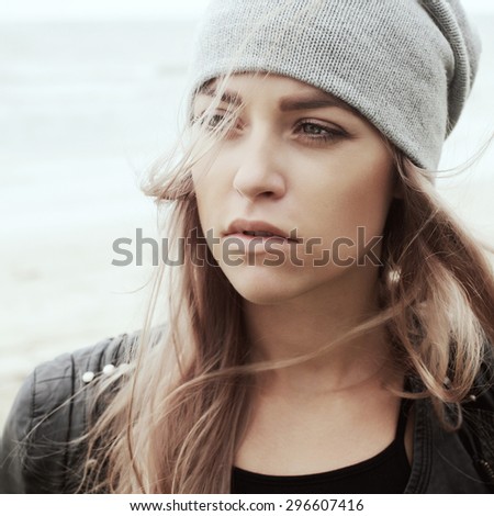 Young woman outdoor summer sensual sad mood cold weather portrait posing on the wind in hat