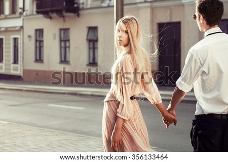 Outdoor fashion stunning sensual portrait of young couple in love walking on the street and having fun together