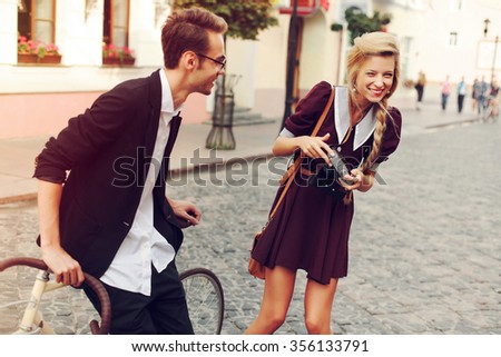 Young beautiful hipster couple vintage style posing outdoor on the street fashion style having fun together laughing