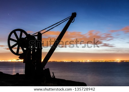 Silhouette of a davit in the evening with Dublin port backdrop