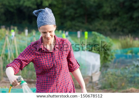 Woman using a garden hose nozzle