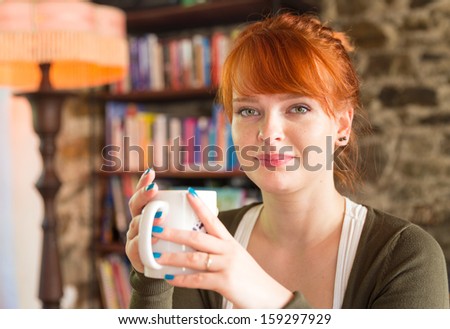 Gorgeous red haired woman holding a cup of tea