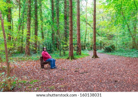 Man sitting on a bench in a forest in autumn