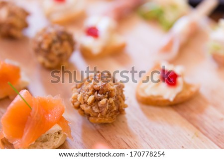 Portions of Hors D\'oeuvres on a wooden platter