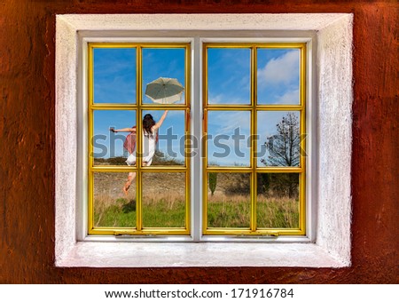 Young woman flying away with an umbrella seen through a window