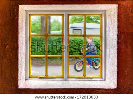 Little boy riding a bike outside the house
