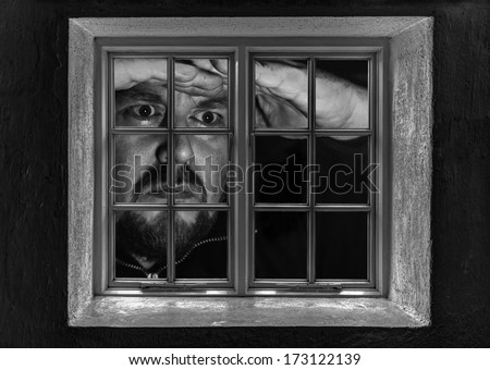 Man giant looking through a window at night