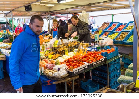 ZWOLLE, THE NETHERLANDS - FEBRUARY 1, 2014: Unidentified man buying groceries at the street market in Zwolle. In the Netherlands there are 18,000 merchants realizing a 2.6 billion turn over.
