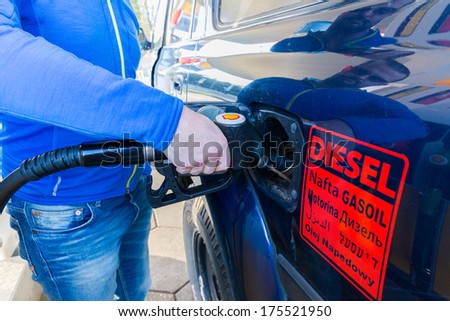 ZWOLLE, THE NETHERLANDS - FEBRUARY 3, 2014: Unidentified man filling up a Toyota Land Cruiser with diesel at a Shell gas station. Shell have 44,000 service stations worldwide.