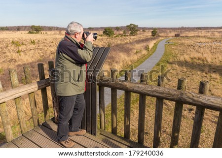 Senior man taking photos from a watch tower