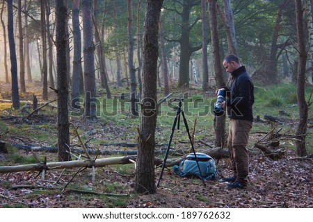 Photographer preparing to take some photos in a forest