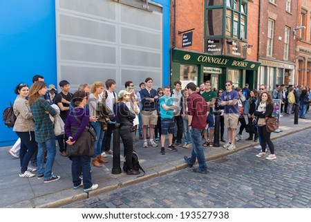 DUBLIN - MAY 17, 2014: Group of tourists on a guided tour in Temple Bar. Temple Bar in Dublin city is a popular tourist destination.