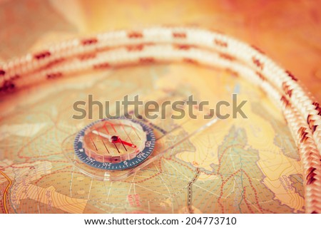 Compass lying on a map with rope