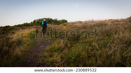 Active woman running downhill early morning