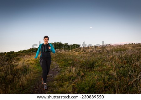 Active woman sprinting downhill early morning