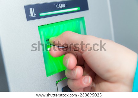 Woman inserting her bank card at an ATM