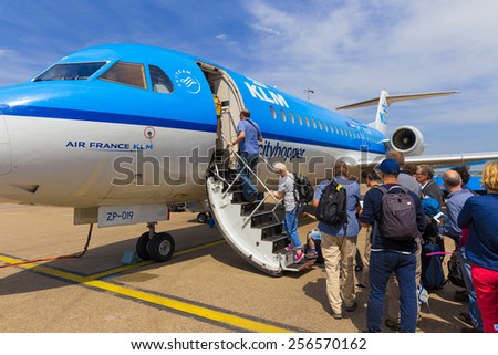 AMSTERDAM - 19 JULY, 2014: Travellers to Toulouse in France are boarding an Air France KLM Cityhopper Fokker F70 at Schiphol Airport in the Netherlands.