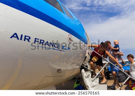 AMSTERDAM - 19 JULY, 2014: Unidentified family travelling to Toulouse in France are boarding an Air France KLM Cityhopper Fokker F70 at Schiphol Airport in the Netherlands.