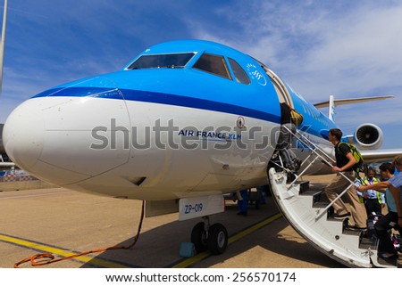 AMSTERDAM - 19 JULY, 2014: Travellers to Toulouse in France are boarding an Air France KLM Cityhopper Fokker F70 at Schiphol Airport in the Netherlands.