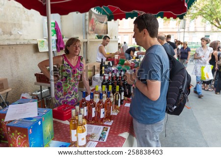 TOULOUSE, FRANCE - JULY 27, 2014: A vendor selling wine at the March Saint Aubin, the Saint Aubin Market, in Toulouse. Marche Saint Aubin is only held on Sundays.