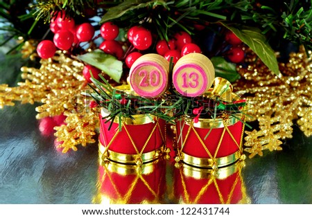 an image of wooden bingo kegs with numbers of coming new year against branch of christmas tree