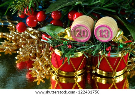an image of wooden bingo kegs with numbers of coming new year against branch of christmas tree
