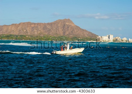 Hawaii\'s famous Diamond Head crater with a fishing boat passing in front