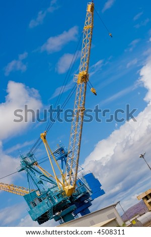 Port construction cranes with a blue sky and clouds