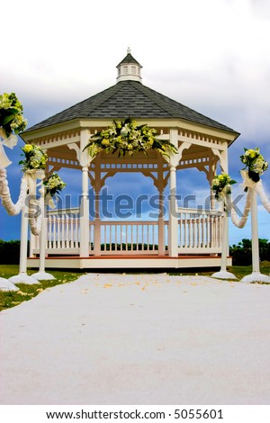 stock photo Wedding gazebo decorated with flowers and a white carpet isle