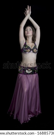 young girl takes the harem oriental dance on black background