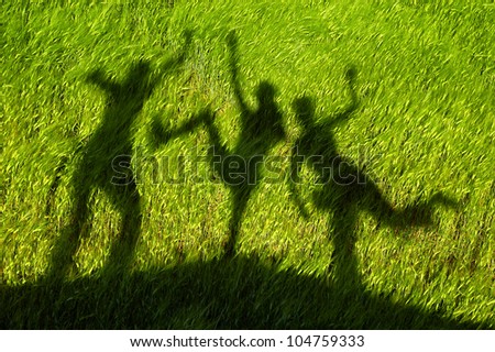 silhouettes of three persons standing with their hands stretched up