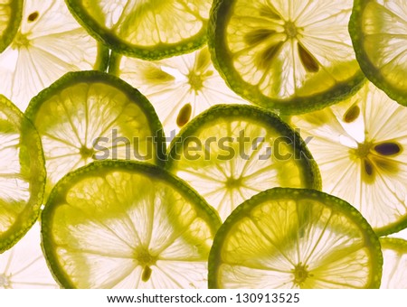 Slices of fresh lemon and lime back lit