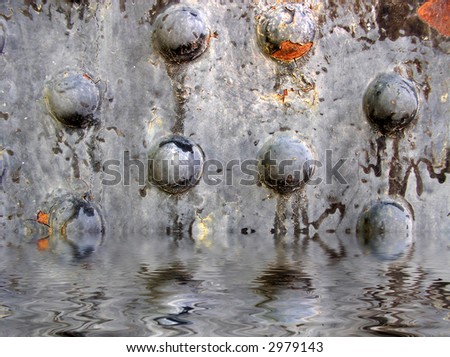 rusted metal rivets with water beneath