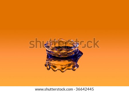 close up of a drop of water on orange backdrop